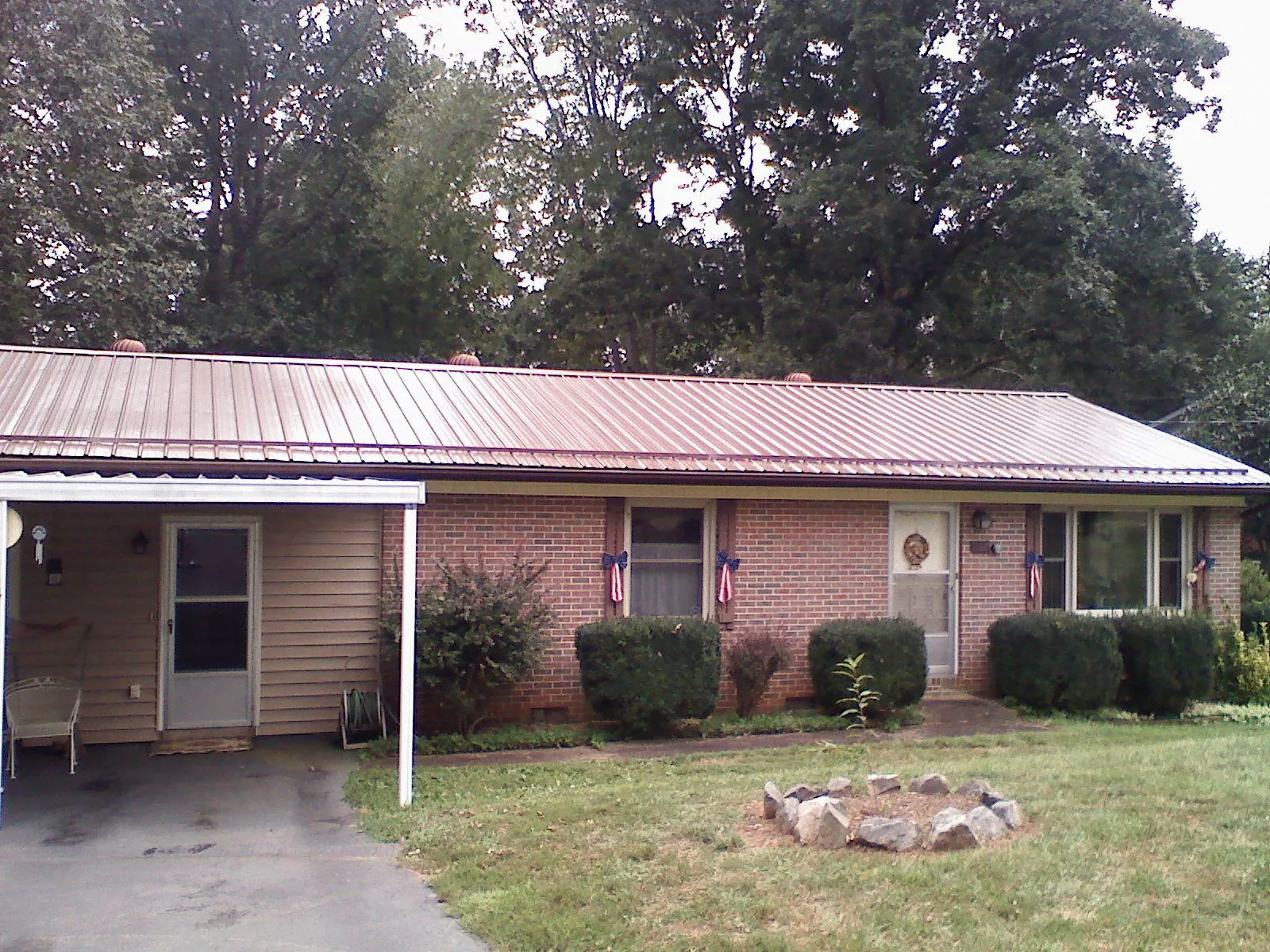 Bronze metal roof and carport on a brick ranch home — Roof Repair work by our crew in Atomic City